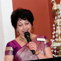 Prabhati Milton holding a microphone and hosting a wedding ceremony
